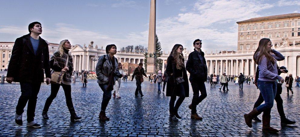 Walking across the plaza at the Vatican in Rome while looking around